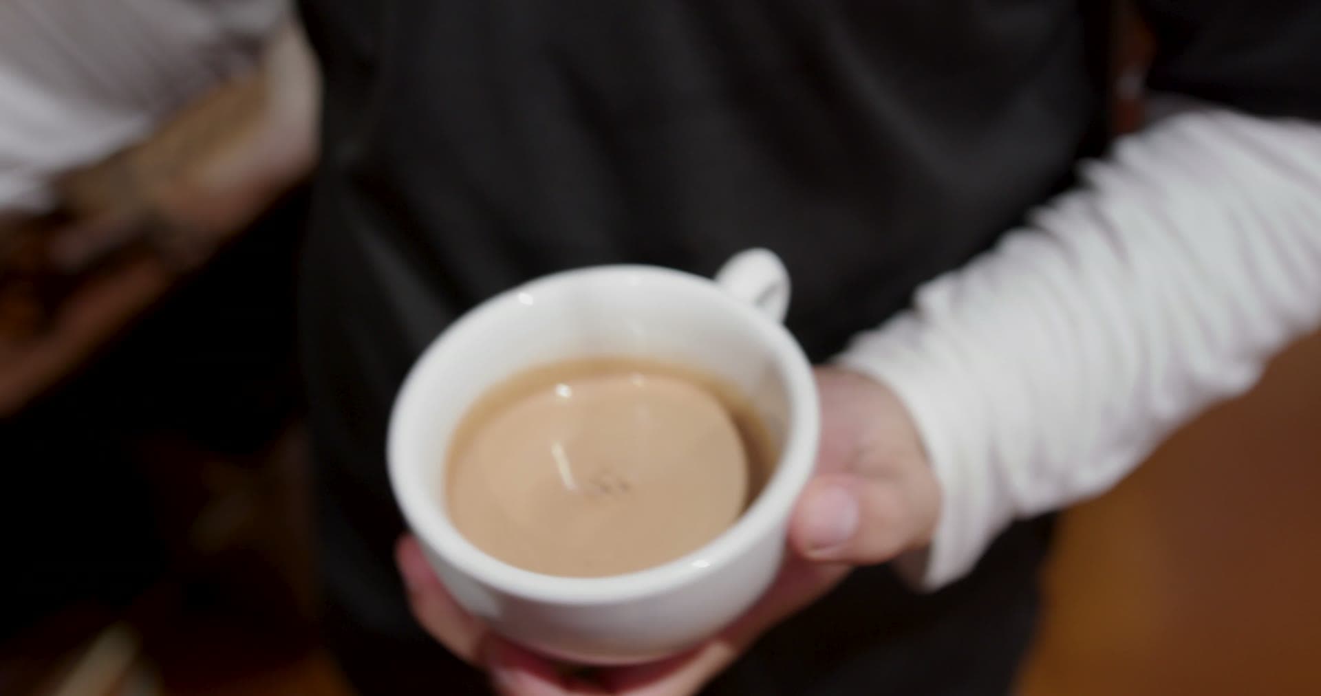 Steam rising off a fresh espresso drink on the counter