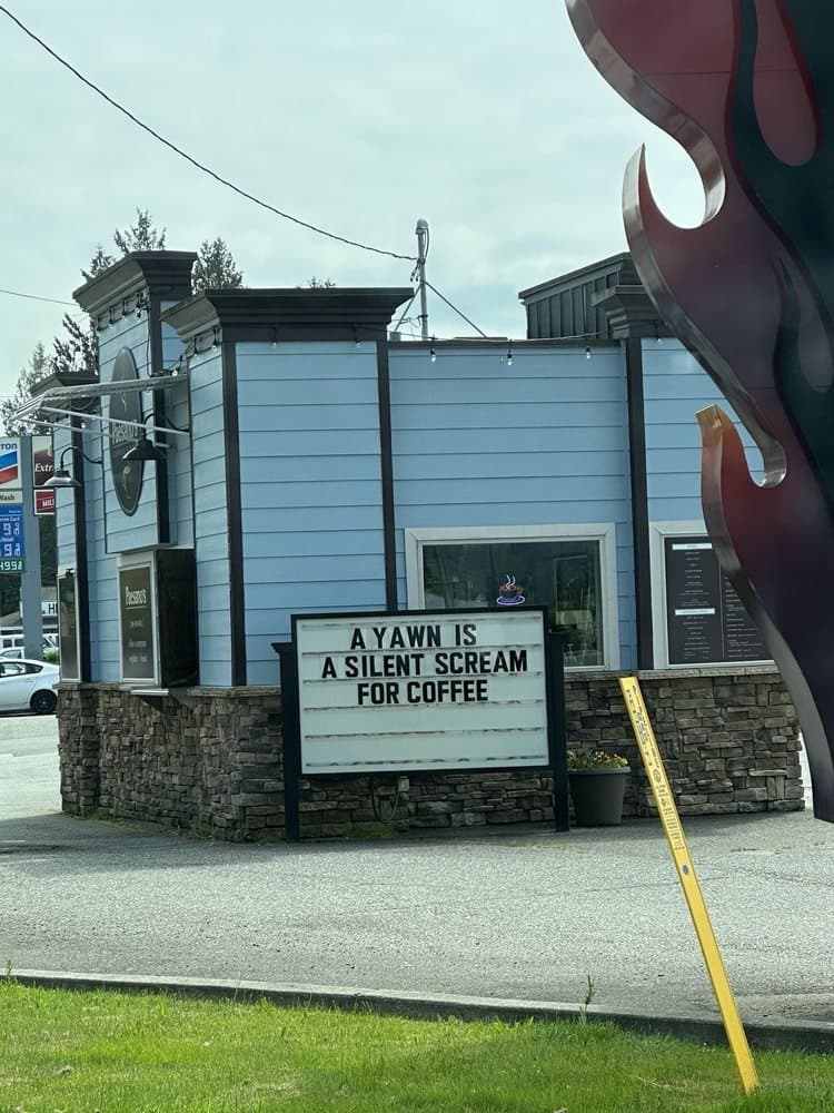 The Highway 2 drive-through stand — light-blue siding, dark trim, and the changeable-letter sign out front